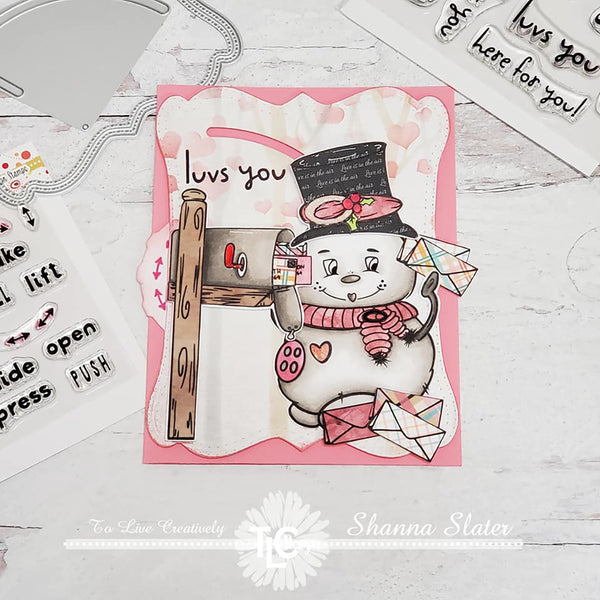 It's the Snow Family Fun son stamp from the digital illustrations available at TLCDesigns.shop.  Prominenantly placed right next to the post box, he's getting his cards in the mail, just in time for the holiday's!  Top hat and all!  The double dial die makes his hat blow on and off of him while he's getting the job done!