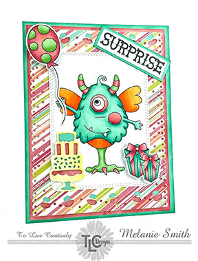 It's a colorful birthday for One Eyed Harry, his balloon, cake and presents today on an adorable striped designer paper cut out with the Celebrate Frame die from TLCDesigns.shop! He's stamped out, colored in mint green copic markers and propped up in the center of the card! Just where he belongs!