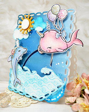 It's an ocean scene with the Fancy Fin digital stamp illustrations from TLCDesigns.shop created to move interactively on the card project with the Double Dial Die 1 product. It's a floating pink whale!