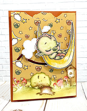 Dreamer Dragon is swinging amongst the clouds and stars on this card with the help of the Double Dial Die interactive product from TLCDesigns.shop! The sweetest dragon baby in his hammock swinging just over the mushroom filled meadow with coordinated designer papers and copic coloring! and the Dragons in Autumn Designer paper!