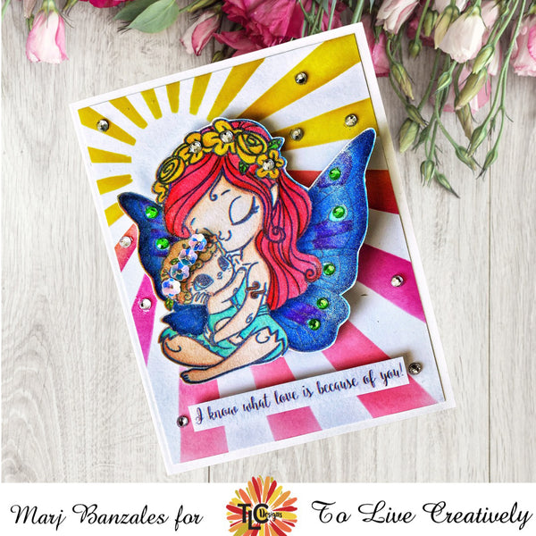 Release Designer Marj has designed a delightful greeting card with Blessings.  The red headed beautiful fairy stamp is placed front and center with a starburst stencil background