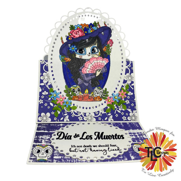 Exclusive to TLCDesigns.shop LaCatrina the polymer stamp propped up to memorialize the Day of the dead featured easel card! The Blooming Medley papers are a perfect fit and the embellishment dies from the Aviary Oval Die!